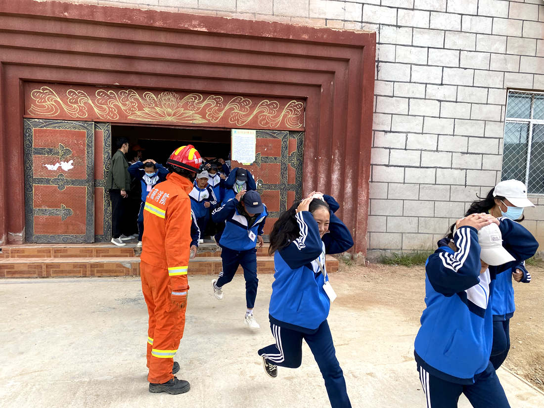 中学生在消防引导员指挥下开展疏散逃生演练。杨海川摄