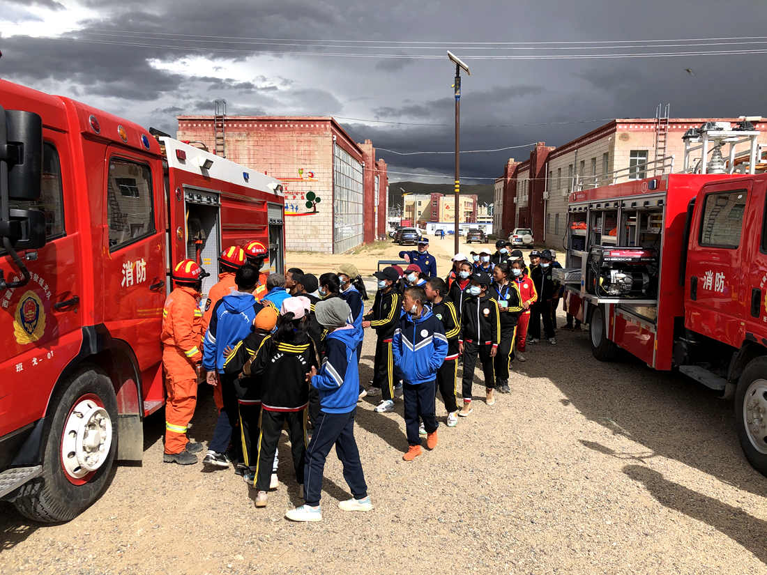 中学生参观大队消防水罐车和器材装备。杨海川摄