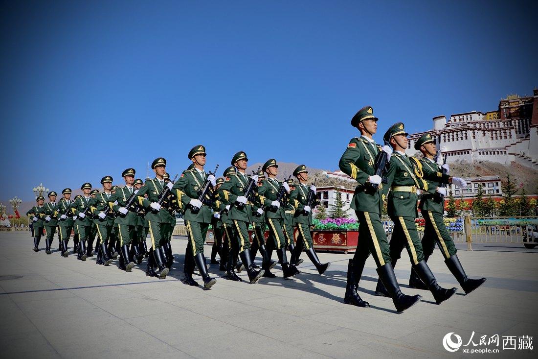 國旗護衛隊隊員緊握鋼槍，踏著威武雄壯的步伐，走向國旗台。人民網 次仁羅布攝