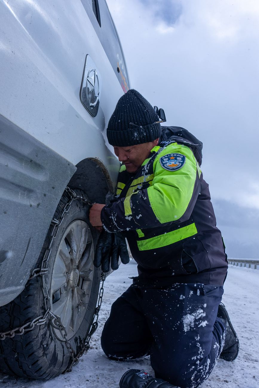 交警在帮助旅客安装防滑链。