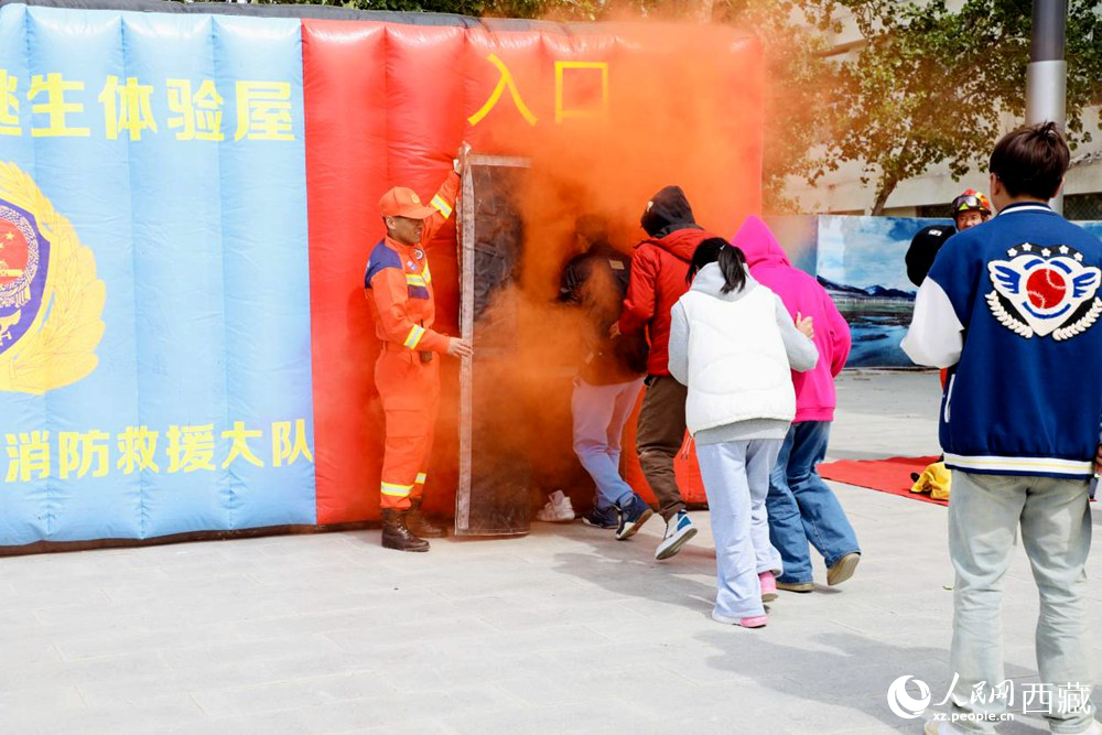 在消防员的指导下现场体验火灾逃生。人民网 次仁罗布摄