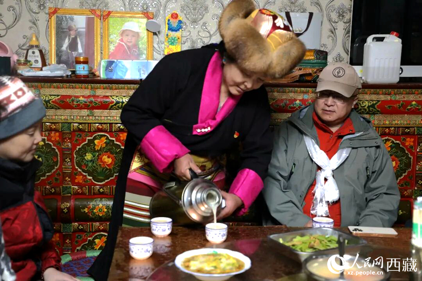 扎西曲登社區的居民在家中熱情招待遠道而來的游客。居民身著盛裝,為游客倒上熱騰騰的酥油茶,桌上擺放著切瑪與特色美食,賓主共話民族團結情誼。人民網記者 吳雨仁攝