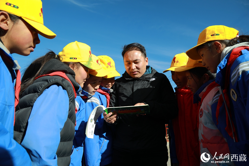 西藏自治區藏醫院專家為拉東村小學生講解天文歷算原理，孩子們圍站聆聽，感受傳統智慧與現代科普的融合。人民網記者 吳雨仁攝