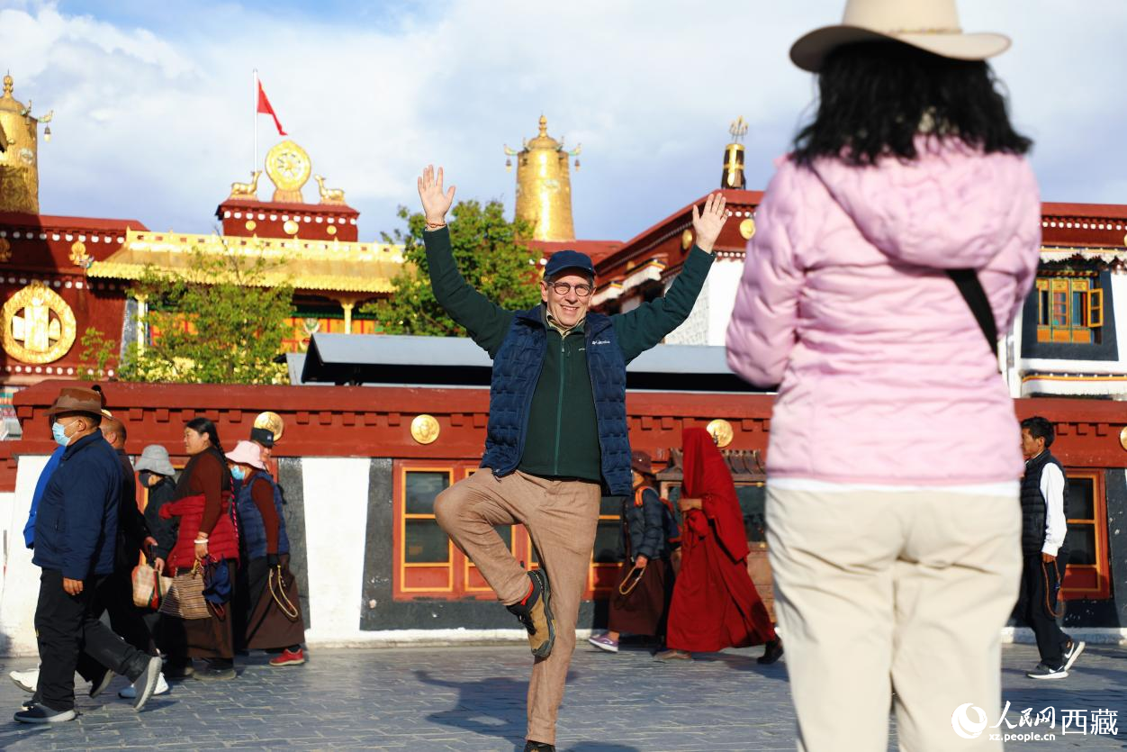 外国游客在拉萨大昭寺广场前拍照记录旅途见闻。
