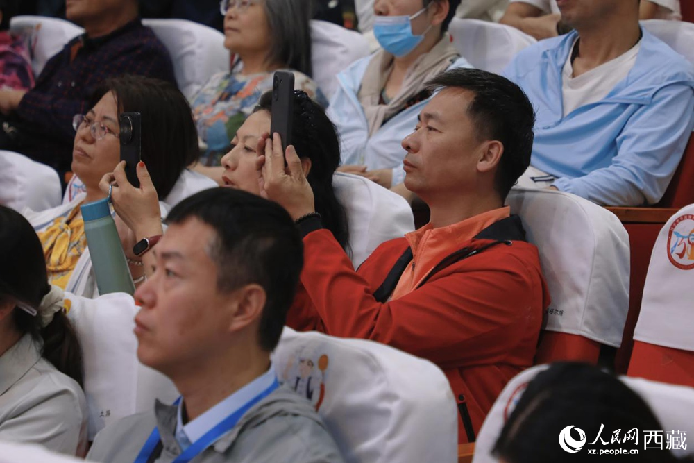 图为游客用手机记录精彩表演,沉浸于浓郁的文化体验中。人民网记者 次仁罗布摄