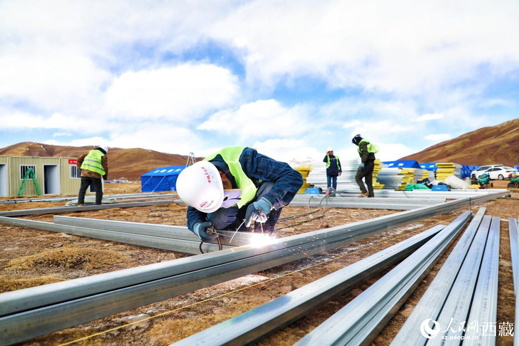 图为中国铁建工人在巴青县岗切乡安置点焊接搭建板房。