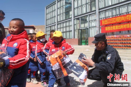 西藏边境派出所携爱心企业为西藏学生捐赠校服和助学金