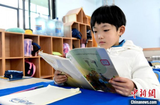 3月14日，西藏拉萨市第一小学一年级六班学生丁增乐吉在阅读藏语课本。　李林 摄