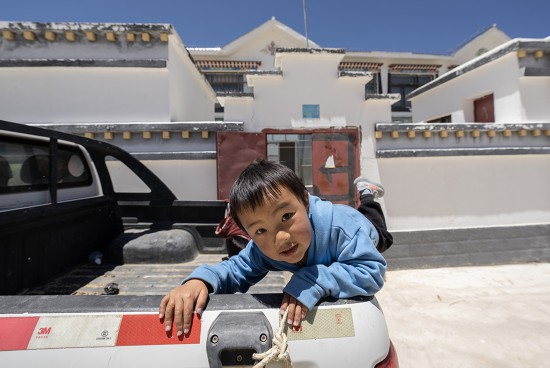 5月28日，洛桑占堆老人的重孙子次仁顿珠在自己居住的典角村“五代房”外面玩耍。新华社记者 费茂华 摄