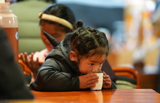 小顾客在“牧人宝库”藏式茶馆喝酥油茶（2月13日摄）。